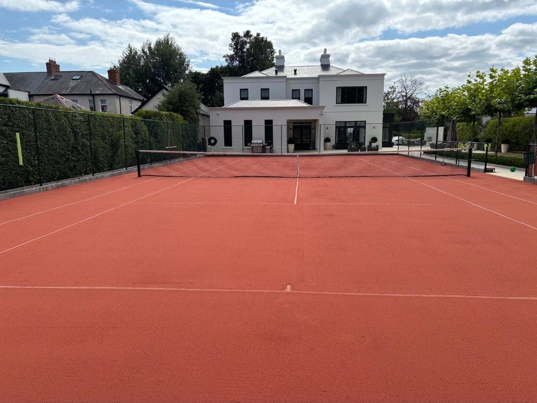 The same artificial clay court after rejuvenation, with an even, laser-smooth infill and clear line markings