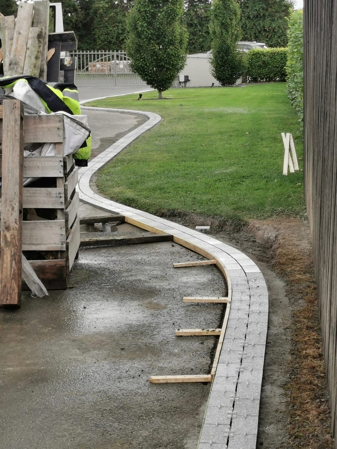 Curved kerb line being set and braced with timber props over freshly poured concrete