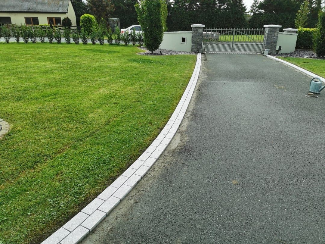 Completed tarmac driveway with granite cobble kerbing curving along the lawn towards entrance gates